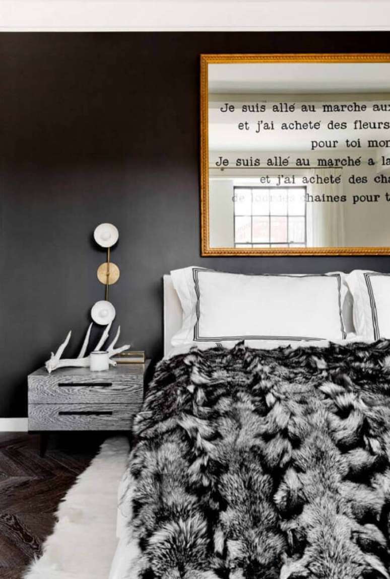 33. Decoração de quarto preto com espelho para quarto sobre a cabeceira com moldura dourada
