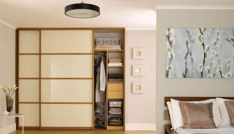 35 &ndash; Modelo guarda roupa casal com acabamento em vidro e madeira.