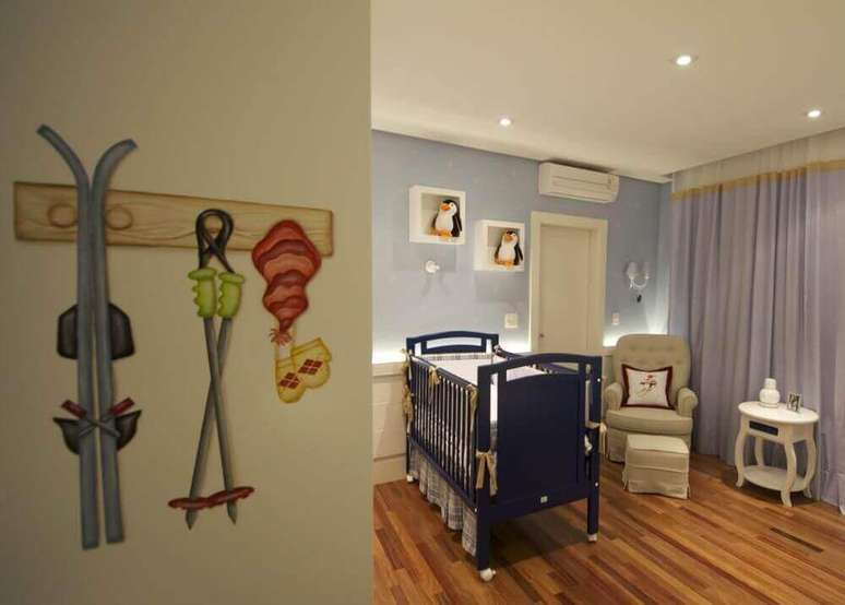 24. Decoração para quarto de bebê com berço azul marinho e nichos brancos decorados com pinguins