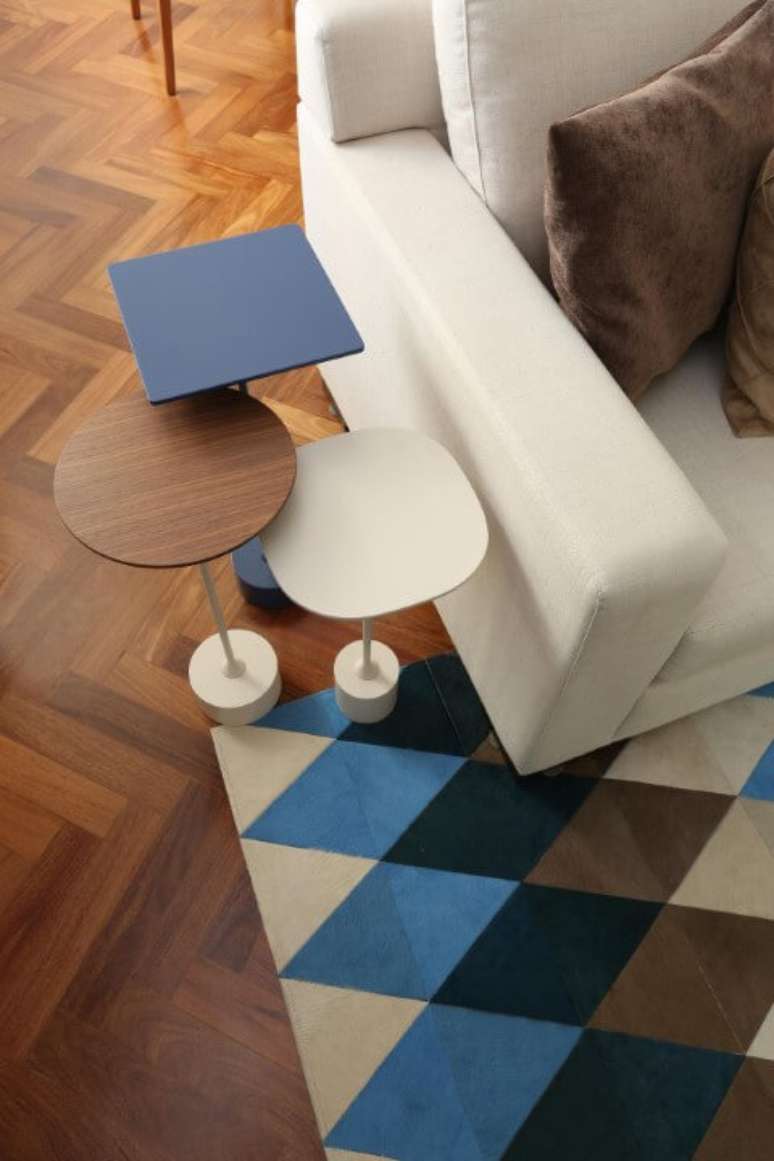 3. Sala de estar com mesas laterais de tamanhos diferentes combinando com o tapete. Projeto de Renata Romeiro