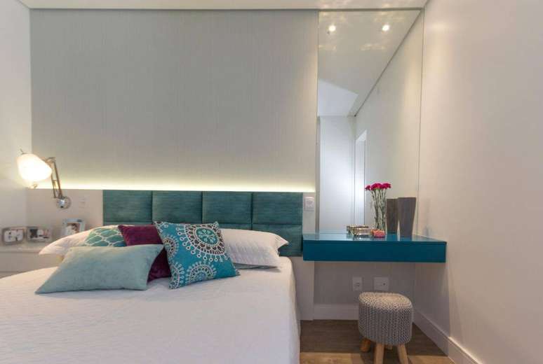 33. A cabeceira estofada colorida pode combinar com almofadas e outros detalhes do quarto de casal. Projeto por Elen Saravalli.