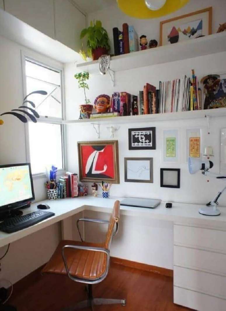 6. Home office tudo branco com mesa de canto para computador e prateleiras para organizar livros e objetos de decoração