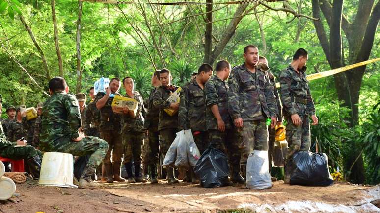 Militares levam suprimentos para a área onde stão concentrados os esforços de salvamento: Retirar o grupo de dentro da caverna é um desafio