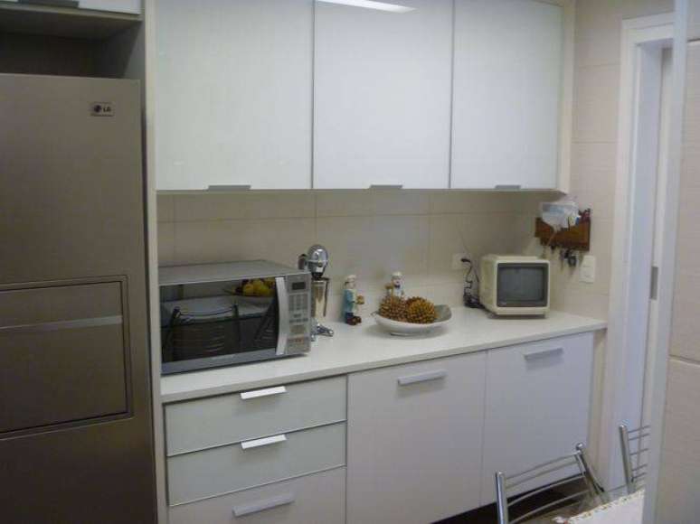 21. Cozinha compacta planejada com armários brancos. Projeto de Ana Laura Wolcov