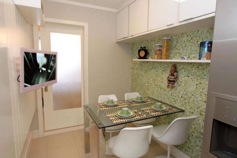 41. Cozinha compacta e moderna com mesa de vidro e armários brancos. Projeto de Lorrayne Zucolotto