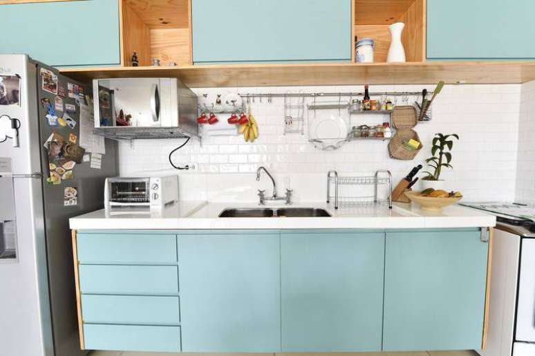 38. Cozinha compacta com armários azuis e revestimento de azulejo metro white. Projeto de Carla Cuono