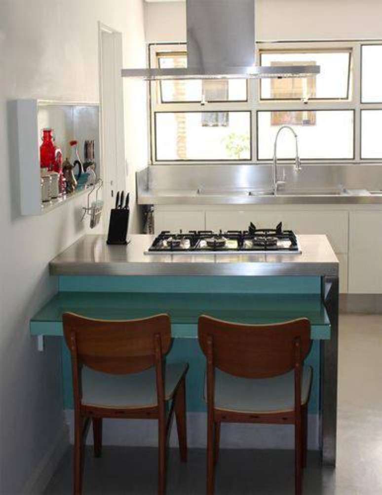 14. Cozinha compacta com bancada com cooktop e mesa pequena. Projeto de Celine Desroches