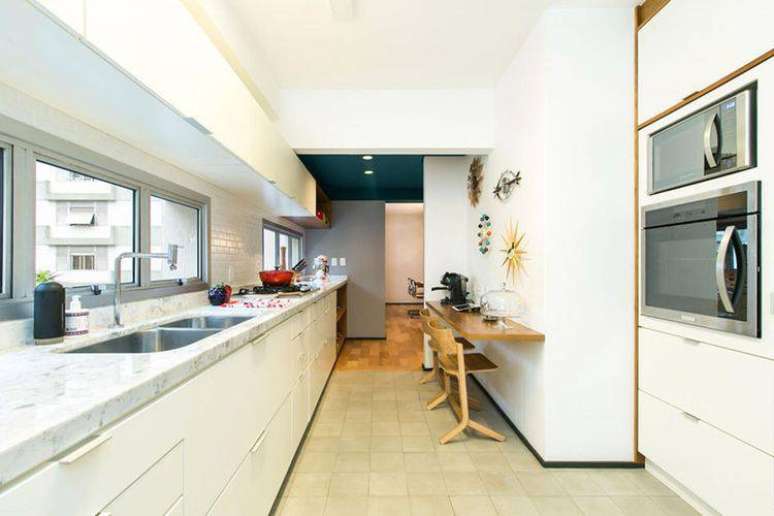 19. Cozinha compacta estilo corredor com a cor branca predominante. Projeto de DT Estúdio