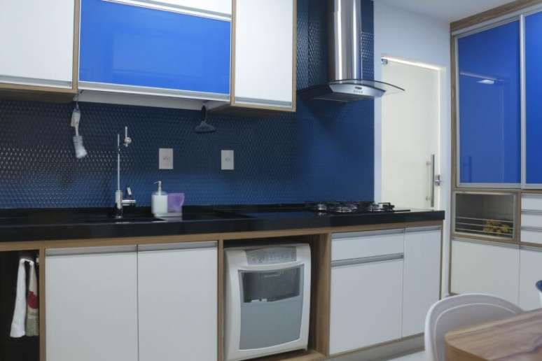 19. Cozinha planejada com parede e móveis em tons de azul e branco. Projeto de Espaço AU