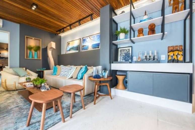 61. Sala de estar com parede, tapete, armários e objetos de decoração em tons de azul. Projeto de Casa Cor Rio Grande do Norte