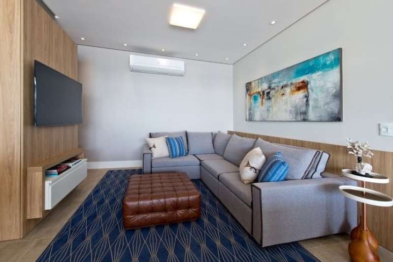 44. Sala de estar com tapete, almofadas e quadro em tons de azul. Projeto de Espaço do Traço
