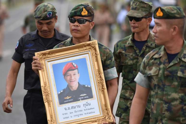 Militares tailandeses carregam quadro com fotografia de Samarn Poonan, ex-mergulhador de elite, morto nos esfor&ccedil;os para resgatar um grupo de meninos e seu t&eacute;cnico presos numa caverna
06/07/2018
REUTERS/Panumas Sanguanwong