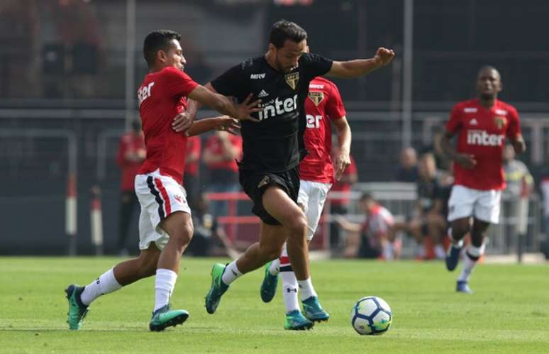 Nenê, um dos principais jogadores do time principal, divide bola com atleta da base (Rubens Chiri/saopaulofc.net)