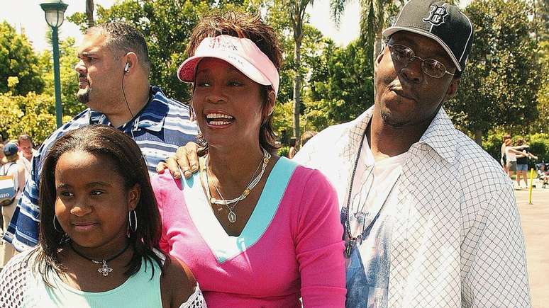 Whitney com Bobbi Kristina e o ex-marido Bobby Brown em 2004; filha foi encontrada inconsciente em uma banheira, três anos após a morte da mãe