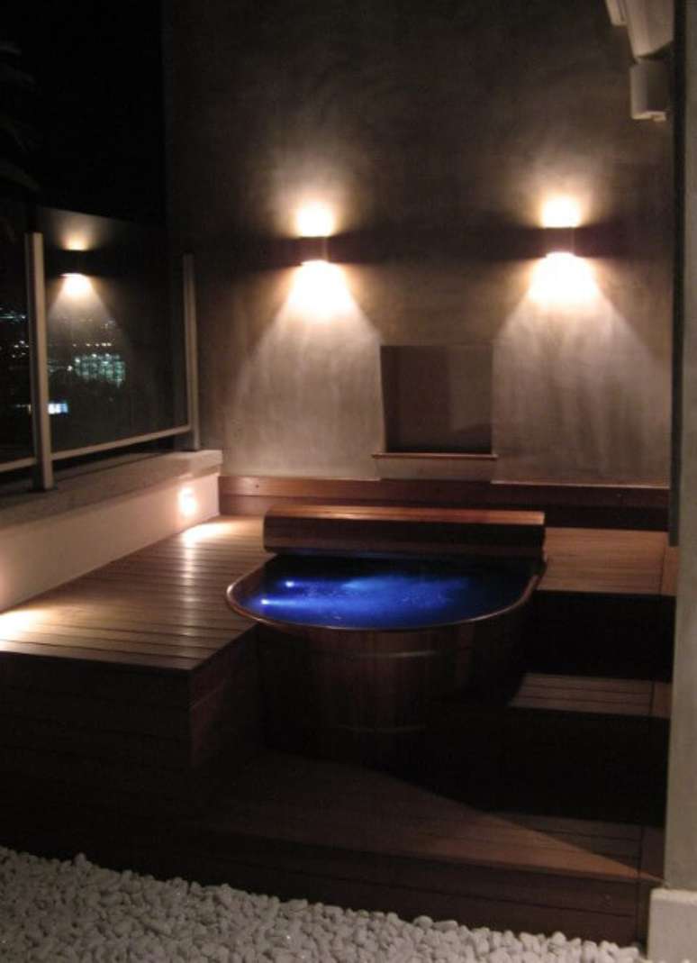 15. Sala de banho externa com ofur&ocirc; com ilumina&ccedil;&atilde;o noturna. Projeto de Andre Martins