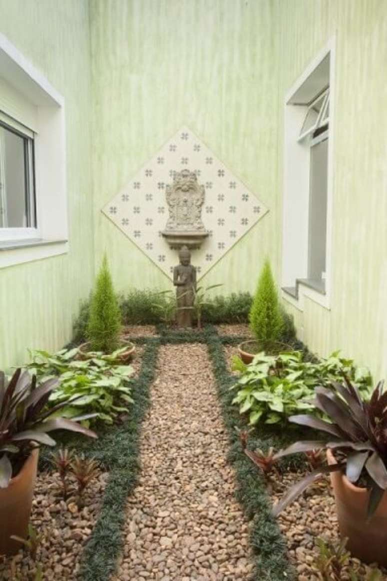 52. Jardim de inverno com chão de pedras e escultura oriental. Projeto de TT Interiores