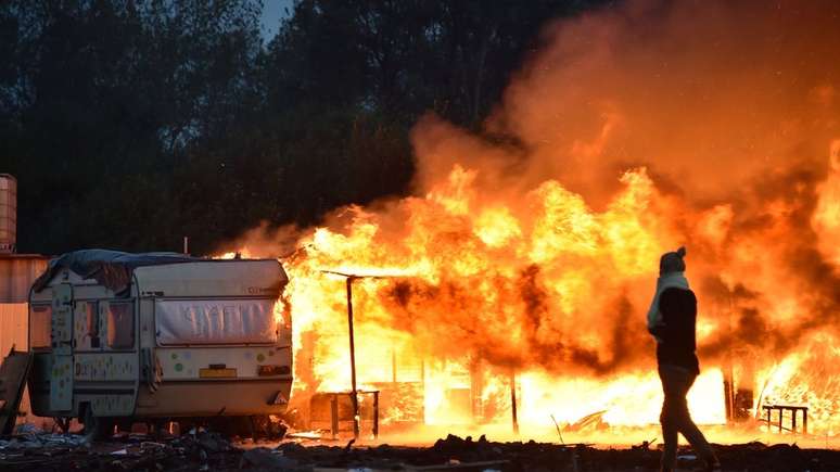 Campo de migrantes em Calais sendo queimado em 2016; tens&otilde;es migrat&oacute;rias cresceram na Fran&ccedil;a nas &uacute;ltimas d&eacute;cadas