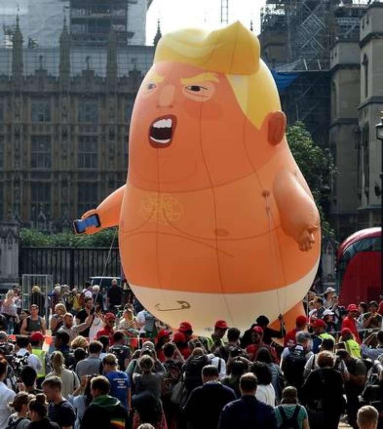 Nas ruas de Londres, o clima é de tensão, com dezenas de manifestantes protestando contra Trump e usando até um boneco gigante do presidente