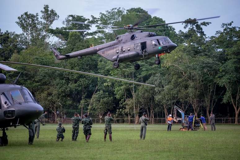 Helicóptero da Força Aérea tailandesa leva uma mini-escavadeira à montanha