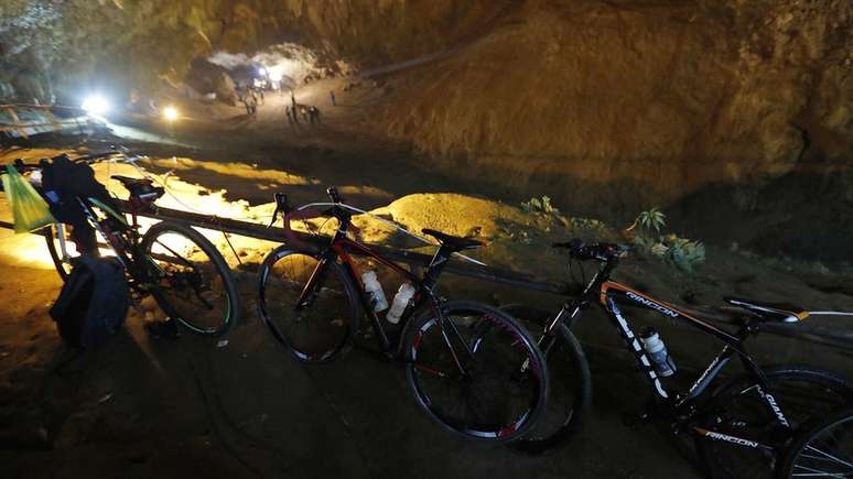 Bicicletas e mochilas deixadas pelos meninos do lado de fora da caverna