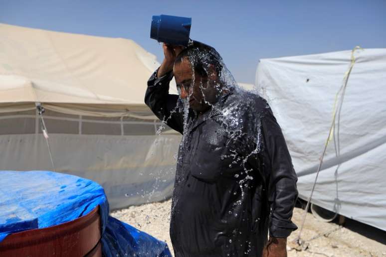 Homem deslocado pela violência na Síria se refresca em acampamento em Raqqa 07/08/2017 REUTERS/Zohra Bensemra