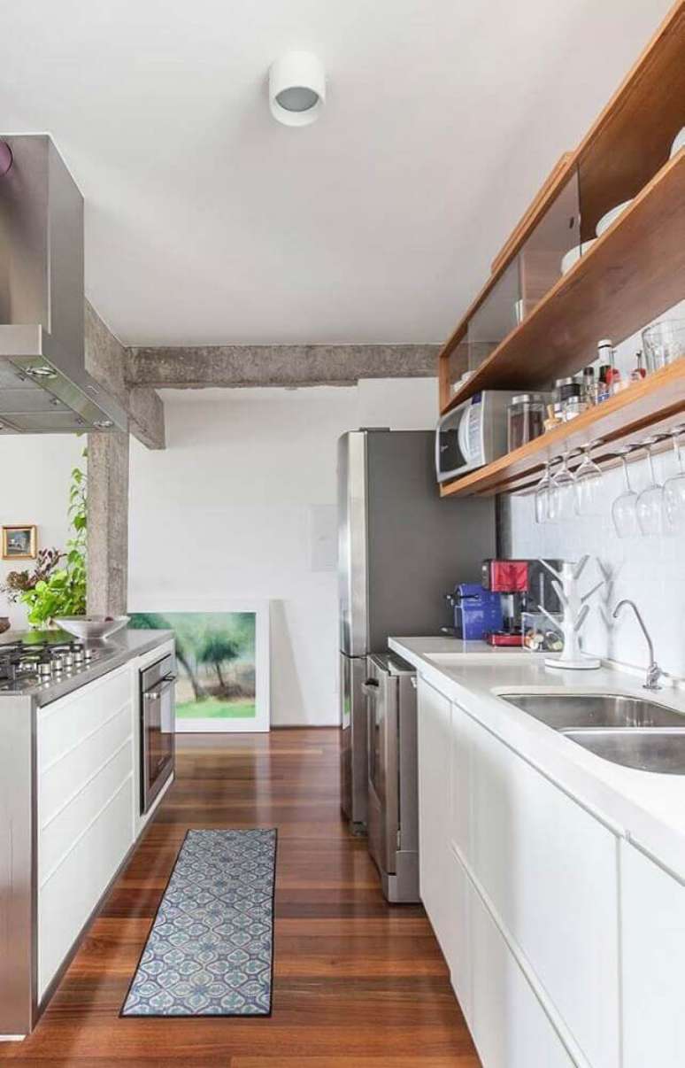 21. Cozinha compacta decorada com nichos para cozinha pequena em tons de madeira