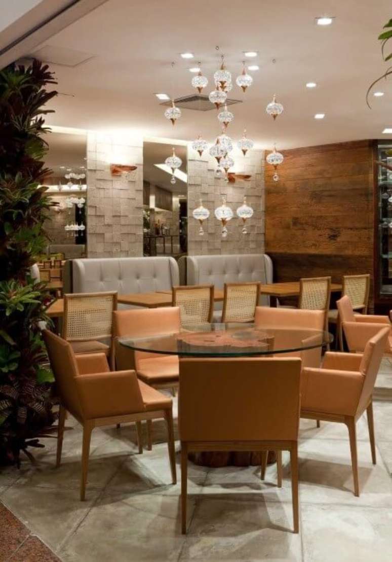 14. Mesa de jantar redonda de vidro com base de tronco de madeira. Projeto de LF Rezende