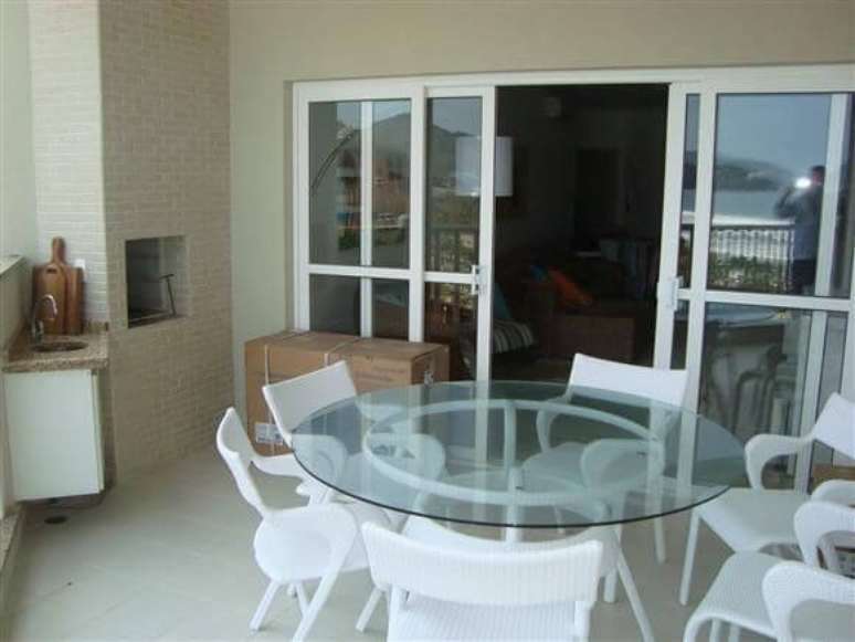 46. A mesa grande pode acomodar muitas pessoas na varanda. Projeto de Kelly Petillo