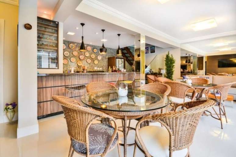 23. Mesas redondas de vidro com base e cadeiras de vime. Projeto de Bender Arquitetura