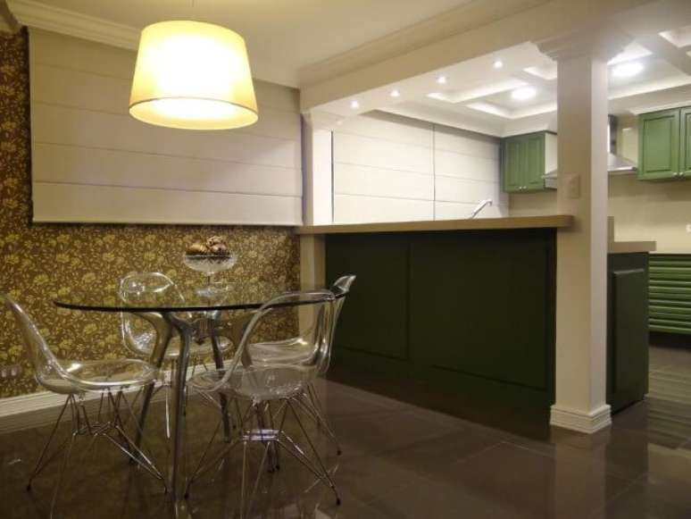 8. Mesa redonda de vidro com base em material cromado e cadeiras incolores. Projeto de Juliana Lahoz