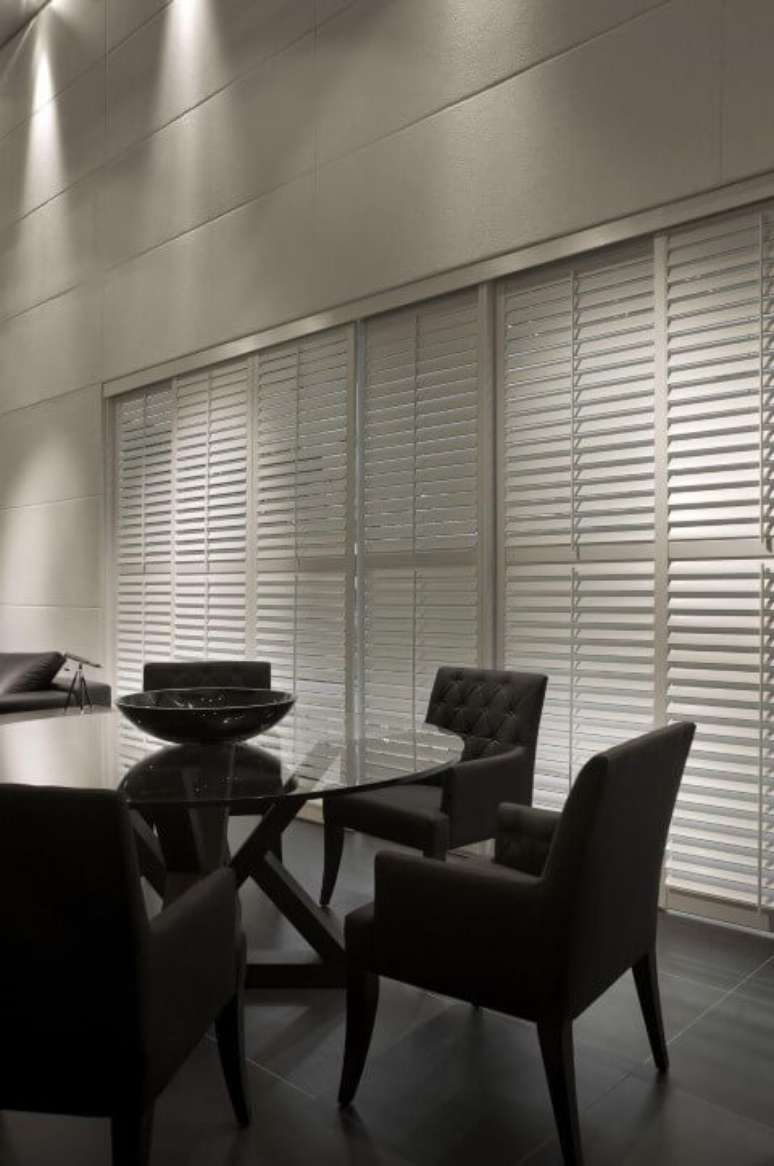 32. Mesa redonda de vidro com cadeiras estofadas pretas. Projeto de Gislene Lopes