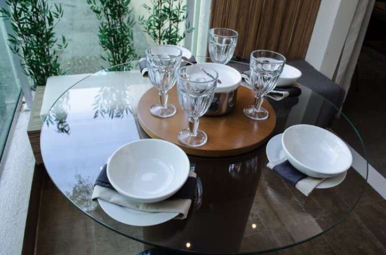 45. Mesa com e banco com almofada branca em varanda gourmet. Projeto de Studio Ecoara