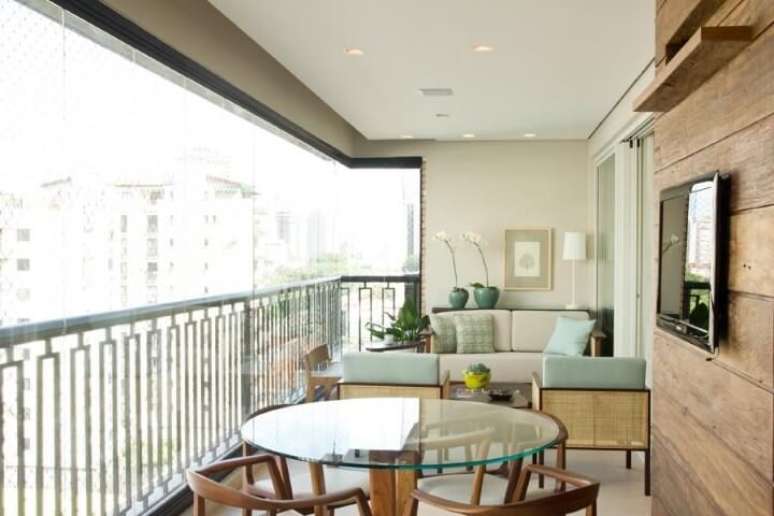 37. Mesa com base de madeira combinando com as cadeiras. Projeto de Marilia Veiga