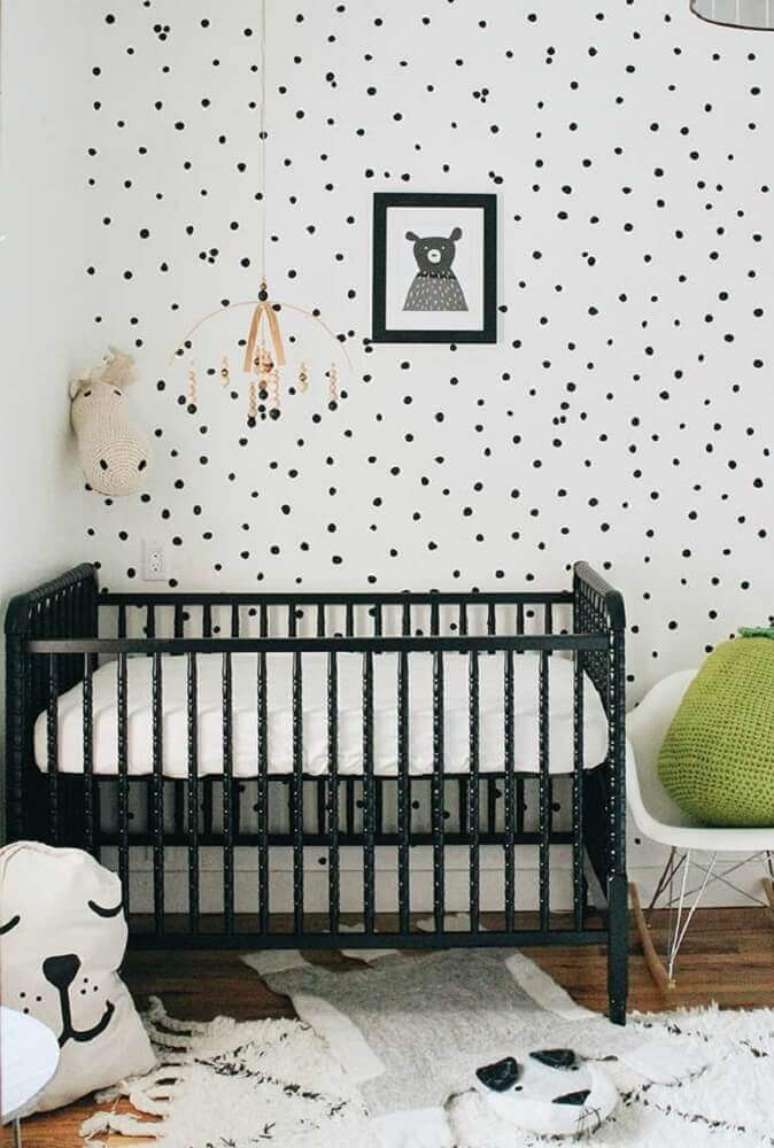 42. Quarto de beb&ecirc; pequeno decorado com ber&ccedil;o preto e papel de parede de bolinhas