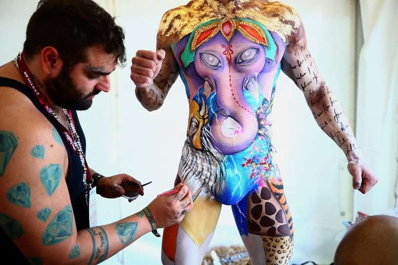 Maquiador Jonathan Pavan, do Brasil, trabalha em pintura realizada em corpo de modelo durante o festival