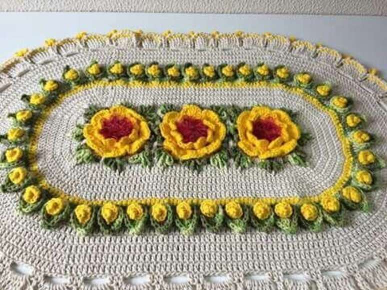 13. Tapete de crochê oval com flores amarelas grandes e pequenas