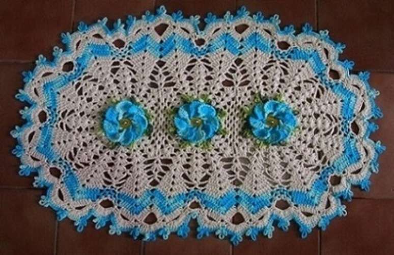 14. Tapete de crochê oval com flor e borda azul