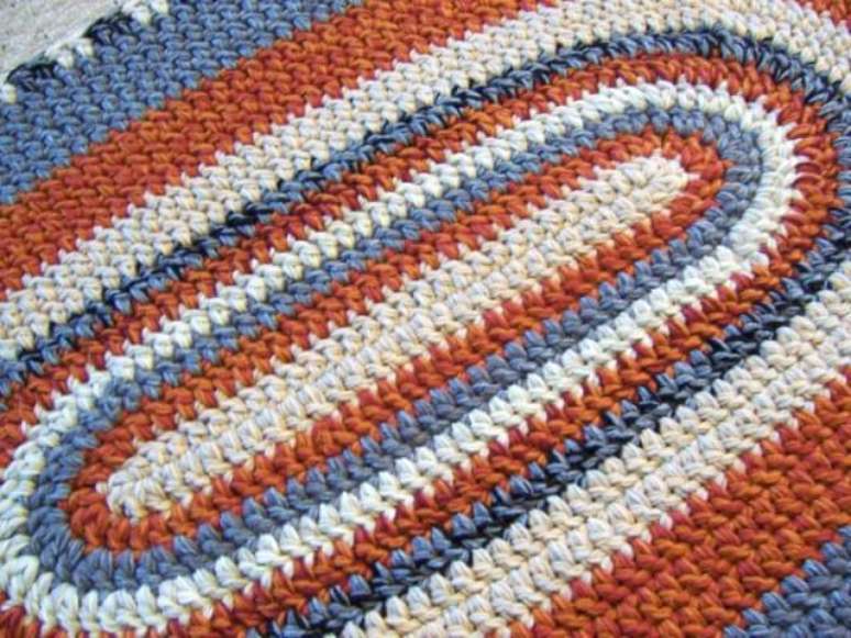 38. Tapete de crochê em tons de laranja, branco e azul