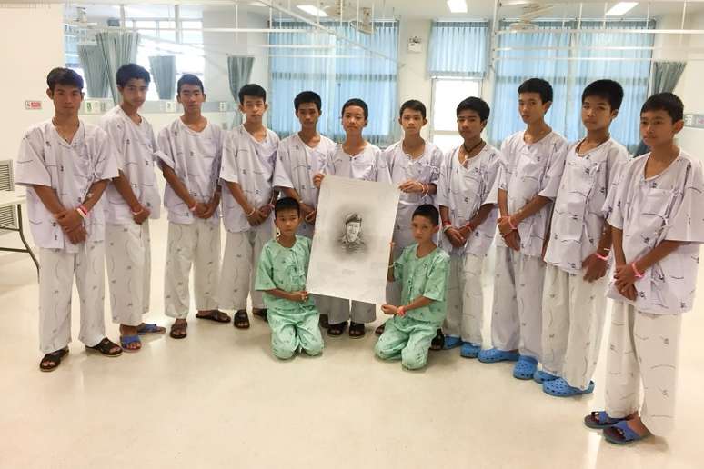 Meninos de time tailand&ecirc;s e seu t&eacute;cnico posam com desenho de mergulhador que morreu durante opera&ccedil;&atilde;o de resgate em caverna inundada

Chiang Rai Prachanukroh Hospital e Minist&eacute;rio da Sa&uacute;de P&uacute;blica/via Reuters