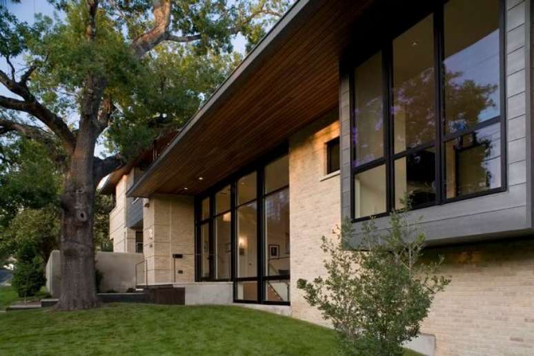 10. Casa de alvenaria com parede de tijolos &agrave; vista pelo lado externo