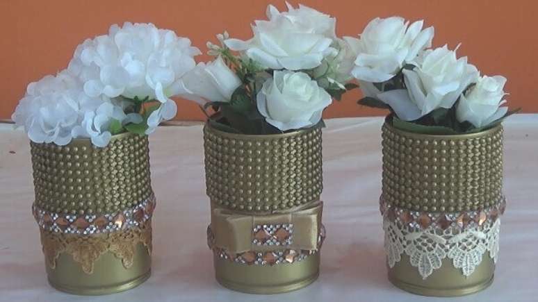 6- Latas decoradas douradas com p&eacute;rolas para enfeitar a sala de estar.