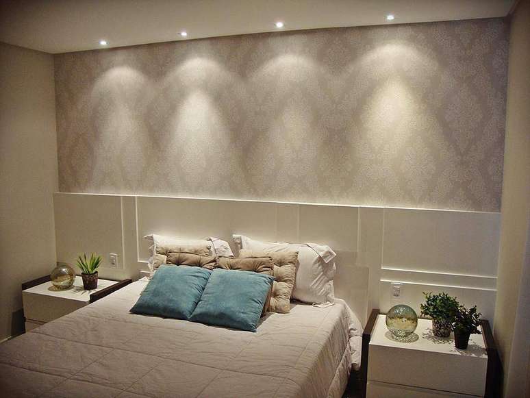 35. O papel de parede no quarto &eacute; valorizado pela ilumina&ccedil;&atilde;o dos spots