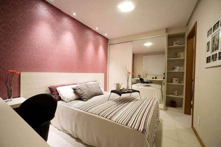 61. O papel de parede para quarto de casal em tom de rosa dá um ar romântico para o quarto