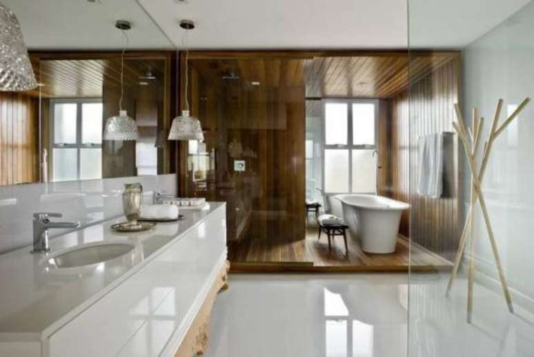 2. Piso para banheiro de porcelanato em uma parte e madeira em outra. Projeto por Leo Romano