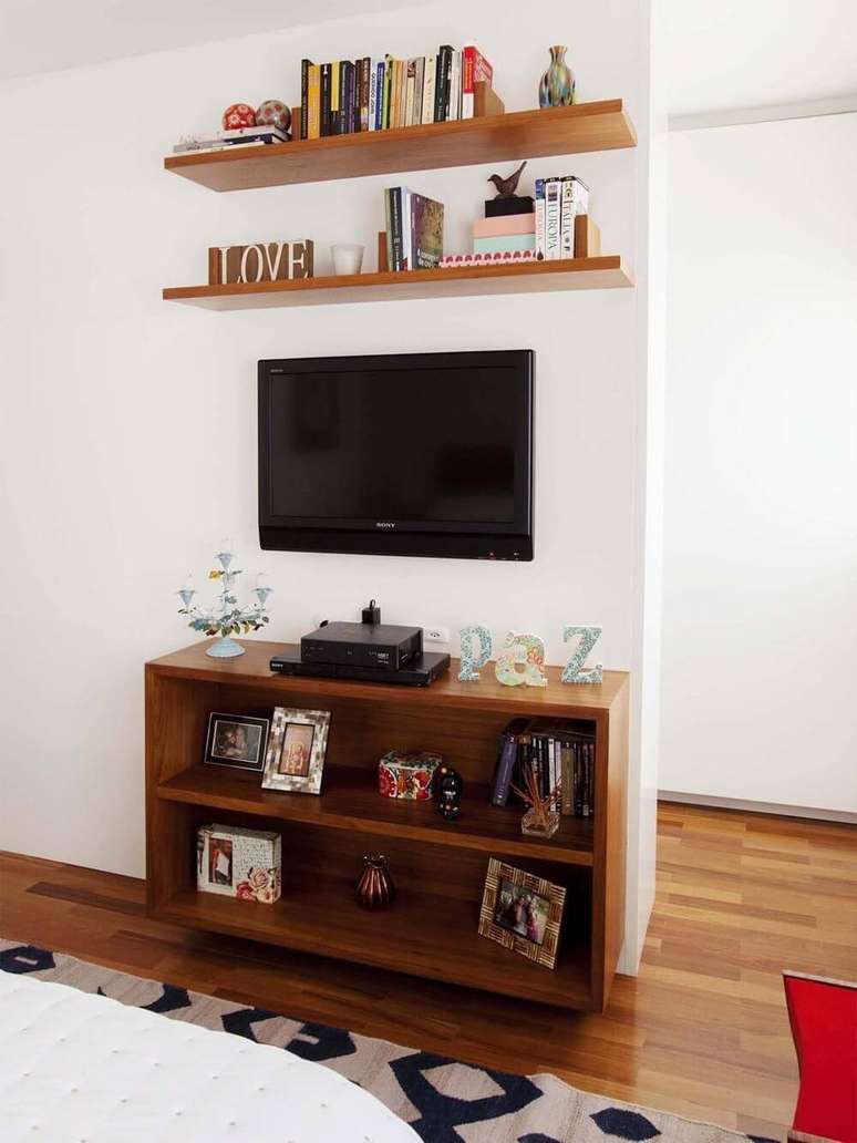 11. A sala de estar composta pelo móvel de madeira mais baixo fica bela e organizada. Projeto por Graziela Arruda.