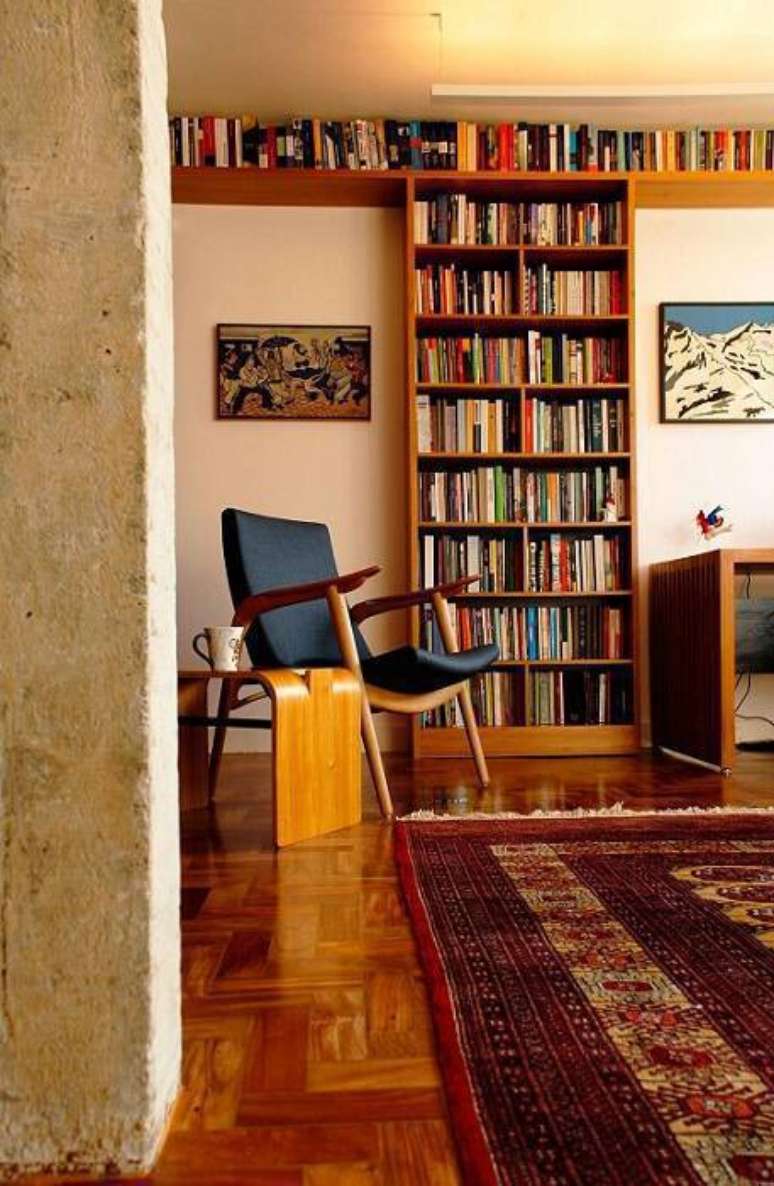 20. Feito em madeira, o móvel traz mais calor ao ambiente e expõe a coleção de livros. Projeto por Odvo Arquitetura.