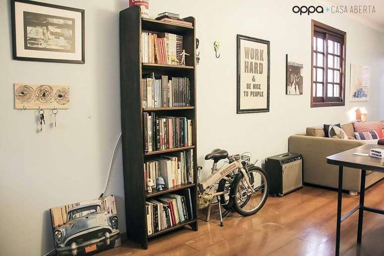 55. O projeto da Casa Aberta traz um m&oacute;vel escuro com decora&ccedil;&atilde;o ao redor.