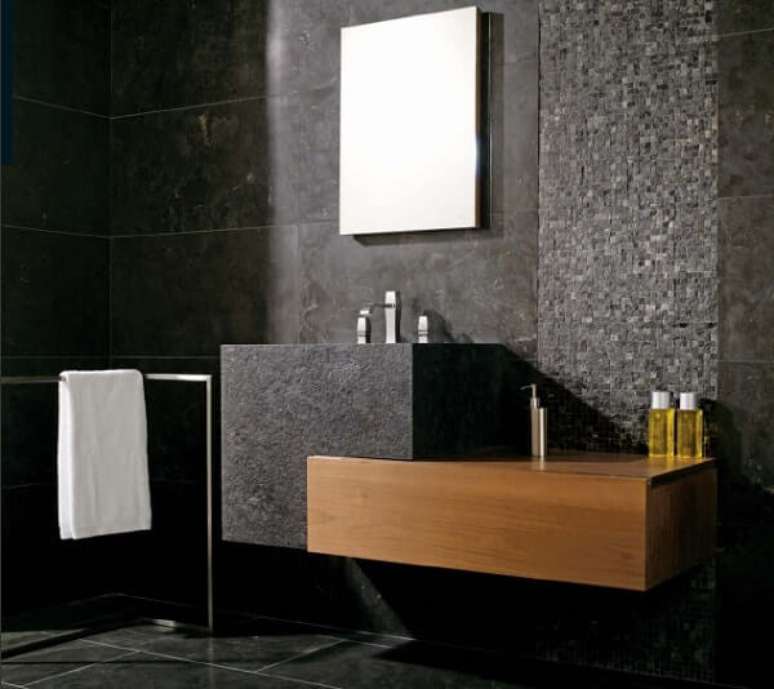 7. Banheiro revestido com parede de pedras naturais combina com o piso cerâmico.
