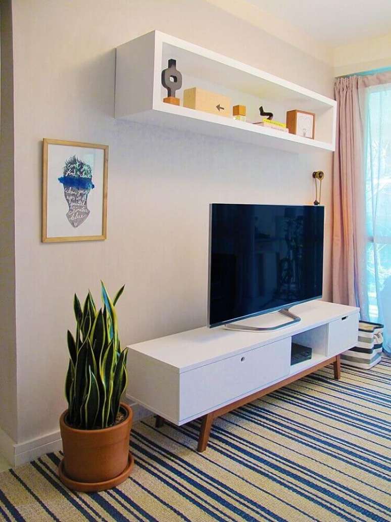 48. Decoração para sala de estar com rack para TV com pés palito e tapete listrado