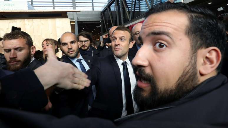 Benalla aparece em primeiro plano em foto de fevereiro, com Macron ao fundo (de gravata preta); 'senhor segurança' foi demitido em 20 de julho